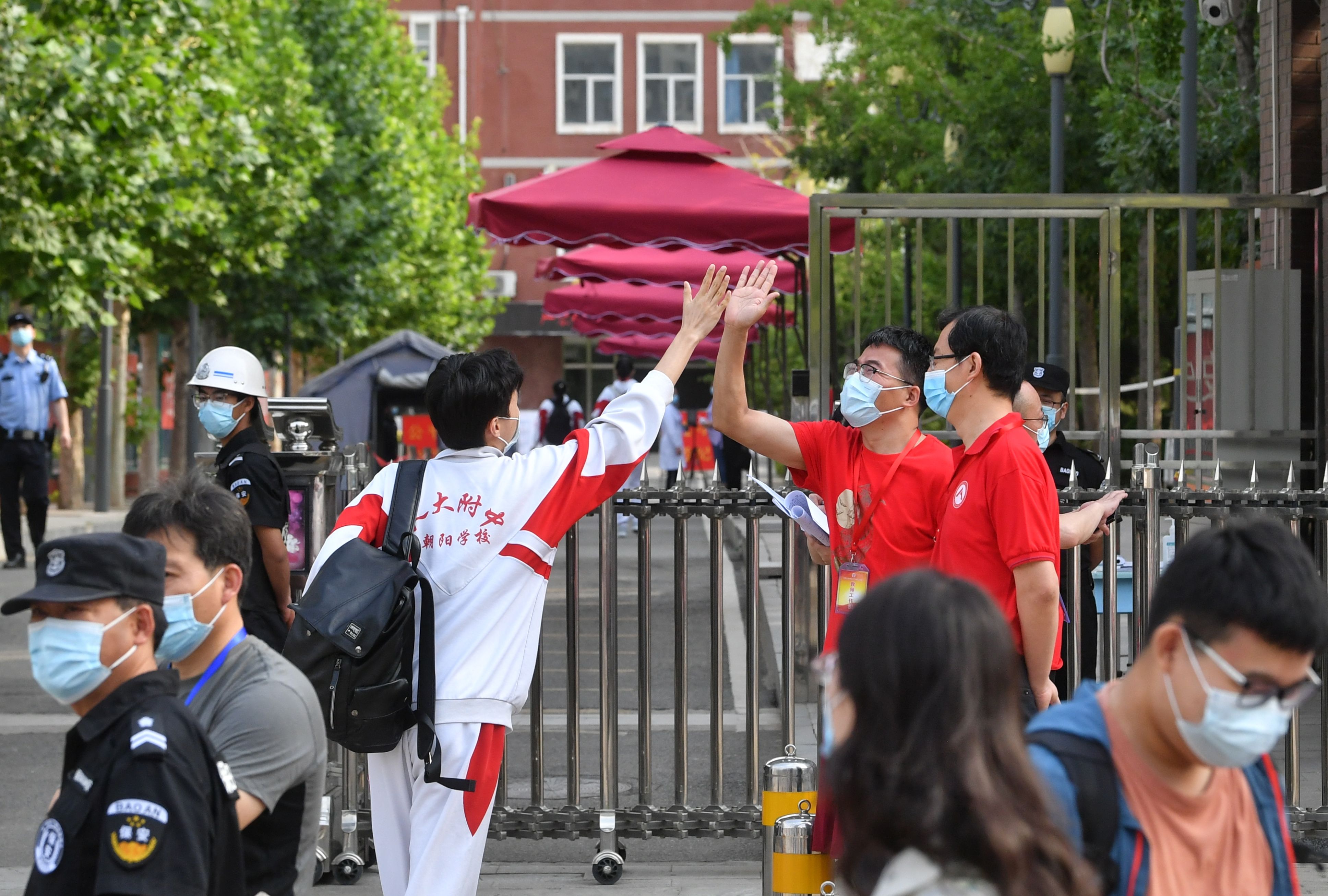 直击高考首日：交警现场疏导，老师和考生击掌、拥抱